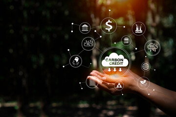 Hands holding a "CARBON CREDIT" cloud surrounded by a network of related icons, symbolizing the interconnected aspects of carbon trading and environmental sustainability.