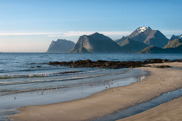 White sand and turquoise blue water.  Small waves of turquoise blue water wash gently across the...