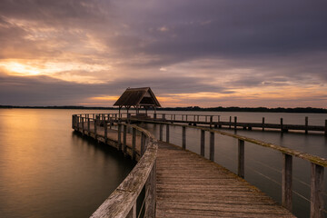 Fototapeta premium The beautiful Hemmelsdorfer See, with its long and large jetty at sunrise.