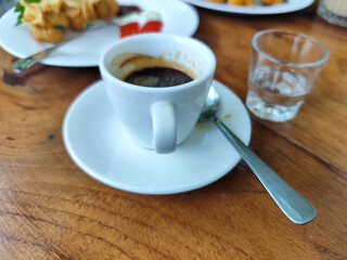 Serve various snacks and drinks on a warm wooden table, in an outdoor cafe. with natural blur.	