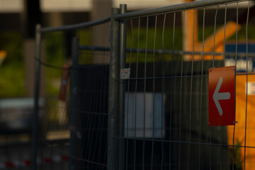 A bright red sign featuring an arrow that is distinctly pointing to the left can be seen mounted on...