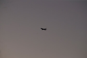 A small plane is soaring gracefully through a cloudy sky filled with shifting grey clouds, showcasing its wings and overall design
