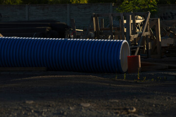A large blue cylindrical pipe is currently laying flat on the ground, indicating possible usage in...