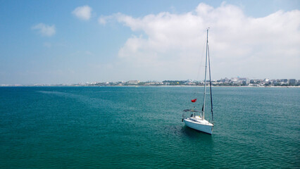 Sailboat Anchored in Calm Blue Waters Near Shore