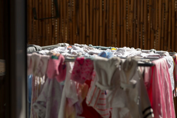 A variety of clothes are currently hanging on a rack outside, showcasing different styles and...