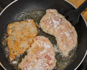 Fried pork chops in a pan with hot oil