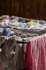 A colorful bunch of various clothes are hanging neatly on a clothes line, swaying gently in the...
