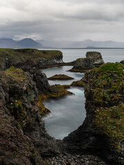 Scenic view of Arnarstapi coastline on a cloudy day, Iceland.