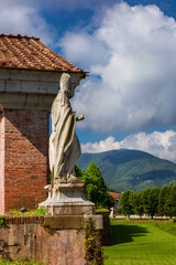 Lucca city walls beautiful park at San Donato Gate with ancient bishop marble statue
