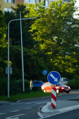 There is a blue sign that has an arrow on it, which is indicating a direction to the right, guiding...
