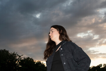 Portrait of a young attractive woman against evening sky