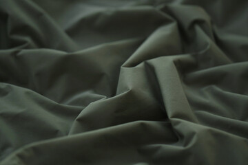 Texture of Dark green military uniform textile cloth with folds