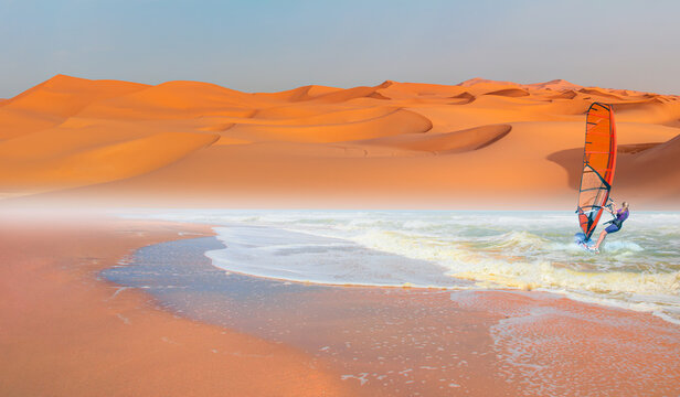 Windsurfer surfing the wind on waves - Sahara desert with Atlantic ocean meets near coast - Morocco, North Africa - Powered by Adobe