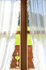 Wooden window with a view of a grass hill in the landscape