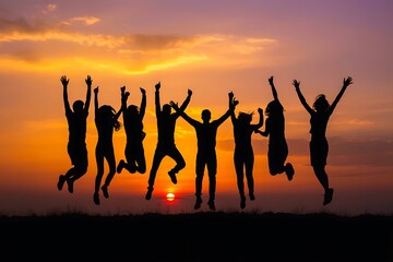 Fototapeta premium A group of friends joyfully jumping together against a vibrant sunset sky