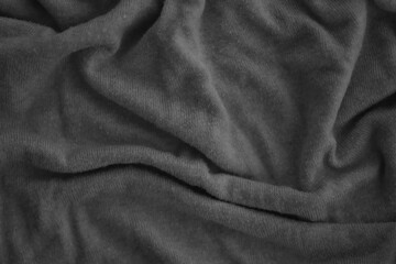 Texture of Dark grey crumpled textile cloth part with small folds