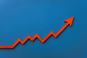 A red upward arrow on a blue background, symbolizing growth or rising trends in finance or...