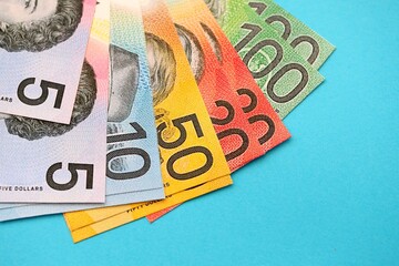 Few modern Australian dollar bills in different denominations lies on blue background
