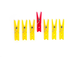 Differentiation from others. The concept of standing out from the crowd. One red clothespin stands...
