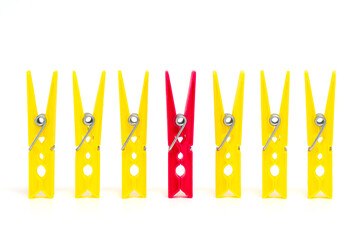 Differentiation from others. The concept of standing out from the crowd. One red clothespin stands...