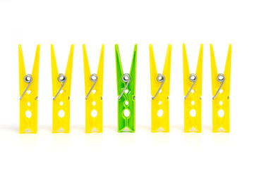 Differentiation from others. The concept of standing out from the crowd. One green clothespin...