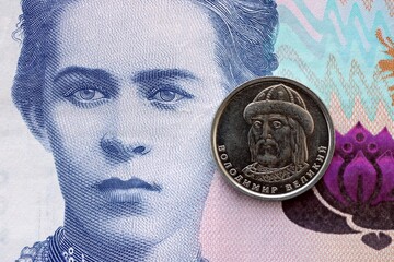 Ukrainian silver coin lies on two hundred hryvnia bill. Financial and business concept. Modern...