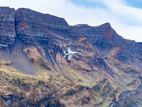 Swiss Air Force F/A-18 Hornet Jet Fighter Flying Low Over Alpine Mountain Landscape
