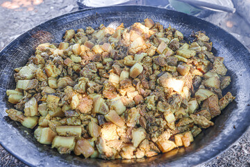 A large dark metal pan was filled with pork.