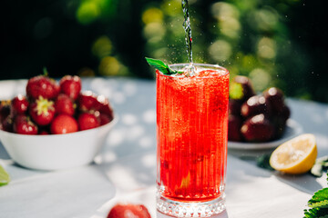 Mojito with lime and strawberry. Amazing iced strawberry lemonade drink on green