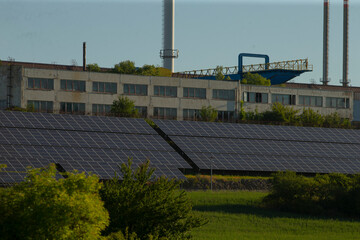 A large and impressive building equipped with a significant number of solar panels placed in front...