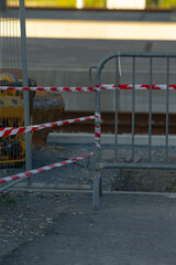 There is a sturdy metal fence that features bright red and white tape wrapped around it for added...