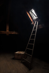 Dark abandoned attic with wooden ladder leading to a small open window and an old wooden crate on...