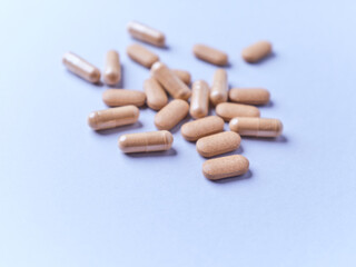 Ashwagandha (Withania somnifera) tablets and capsules on paper background. Soft focus.. Close up. Copy space.	