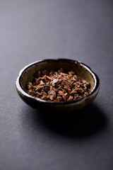 Dry root of Rhodiola rosea. Golden root, rose root. Healthy medical plant on dark paper background. Close up. Copy space.	