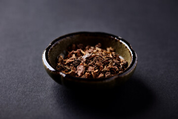 Dry root of Rhodiola rosea. Golden root, rose root. Healthy medical plant on dark paper background....