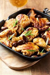 Grilled chicken pieces with kalamata olives and fresh rosemary. Close up.