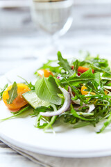 Salad with Tomatoes, Cucumber and Rocket on bright Background. Healthy Snack Idea. Close up.