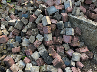 Pile of left over pavers, flooring or concrete block paving, cube shape, red and grey colors
