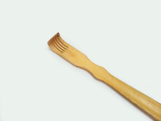 A wooden back scratcher on a white background, a hand shaped itch relief tool with long handle