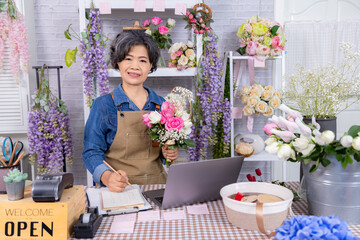Asian senior woman, florist, small business, owner holding bouquet and smartphone in flower shop, presenting service, digital marketing confidence, and floral, modern aging people with technology