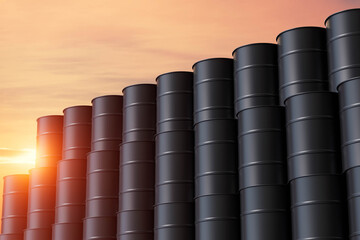 A row of black barrels are stacked up