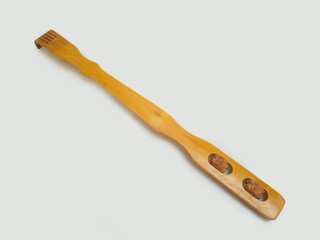 A wooden back scratcher on a white background, back side, a hand shaped itch relief tool with long handle