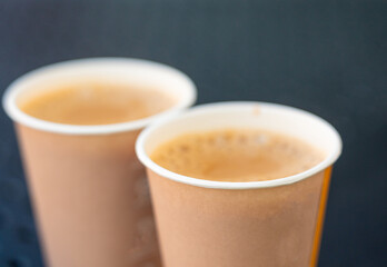 Masala chai an Indian street restaurant, spiced milk tea in paper cup, traditional hot drink