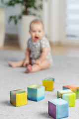 Colorful toy blocks with baby in background