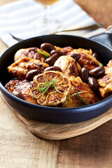 Grilled chicken pieces with kalamata olives and fresh rosemary. Close up.