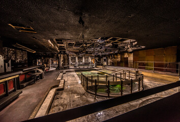 Naklejka premium Abandoned burnt-out disco interior with damaged ceiling and empty pool in a decayed urban exploration site in Germany