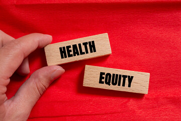 Health Equity message written on wooden blocks on red background. Conceptual Health Equity symbol....