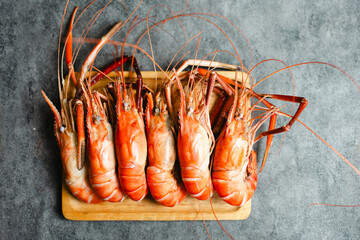 Arrange cooked fresh shrimp in wood plate, ready to eat. Top view