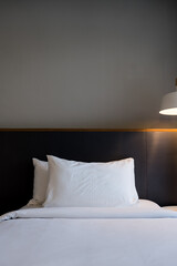 Tidy bed with bedside lamps in modern hotel room. Ready for bed.