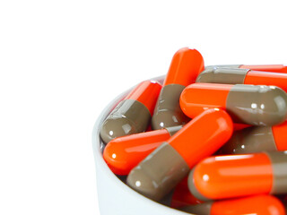 Bulk orange capsule pills on a white tray isolated on white background.